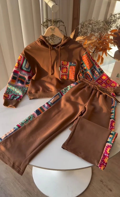 Camel_hoodie_and_pants_with_colorful_geometric_patterns_on_a_white_surface.