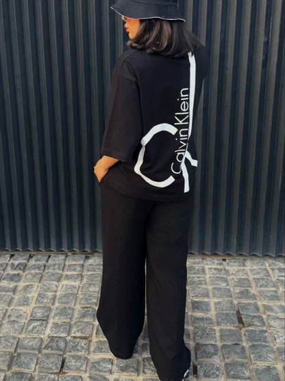 Chakoor Signature Co-ord set featuring an oversized t-shirt with a large Calvin Klein CK logo on the back and matching wide-leg trousers. 02