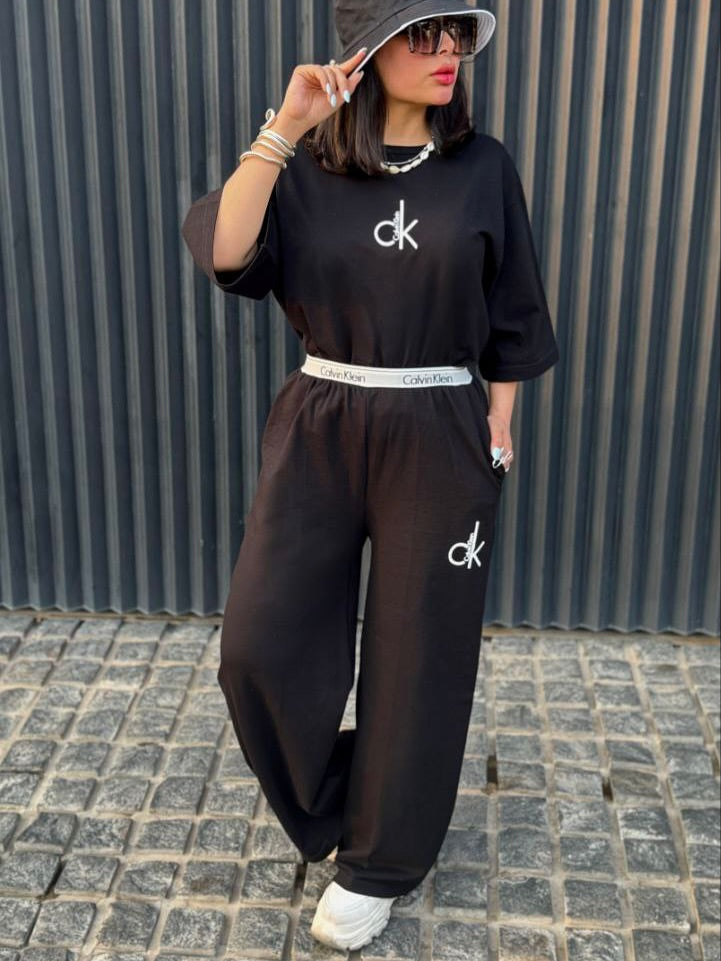 Chakoor Signature Co-ord set featuring an oversized t-shirt with a large Calvin Klein CK logo on the back and matching wide-leg trousers. 04