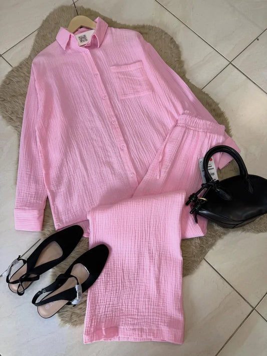Chakoor textured two-piece pajama set consisting of a long-sleeve button-up shirt and matching pants, styled in a flat lay with black shoes and a black handbag on a brown faux fur rug over a tiled floor.