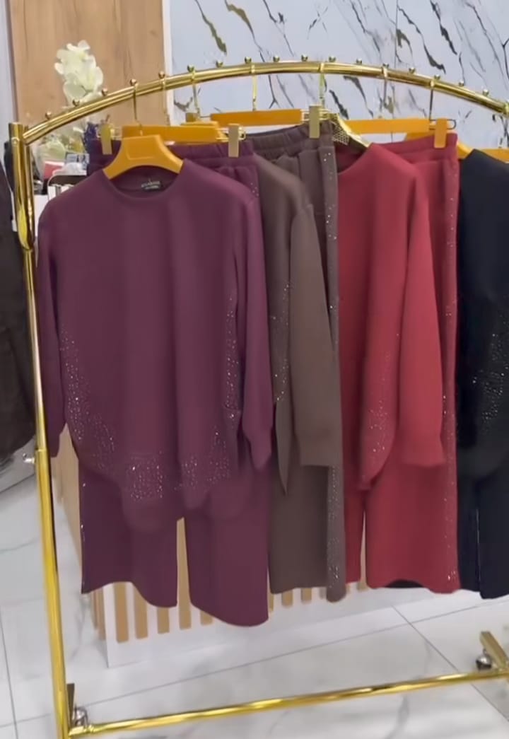 Gold clothing rack with various dresses on a marble floor