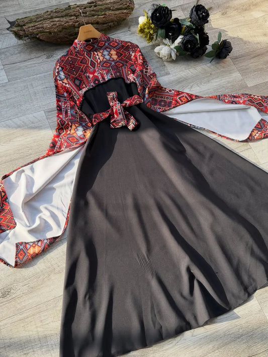 Long black dress with a red and blue geometric pattern on the bodice and wide sleeves, featuring a matching waist belt tied in a bow 01