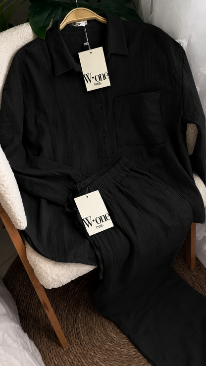 Minimalist two-piece shirt and trouser set with button-down top and elastic waist pants displayed on a chair with soft natural lighting, ideal for casual wear and everyday comfort 09