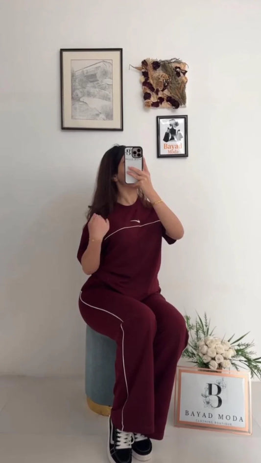 Nike two-piece tracksuit featuring a short-sleeved top and matching track pants with thin white side piping 01