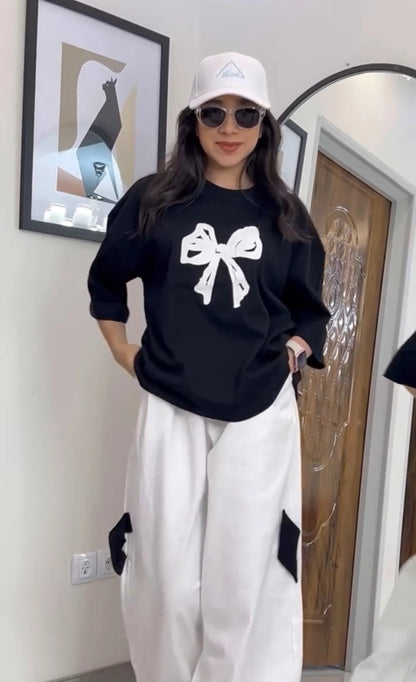 Oversized drop-shoulder t-shirt with a center ribbon bow graphic paired with wide-leg cargo trousers 04