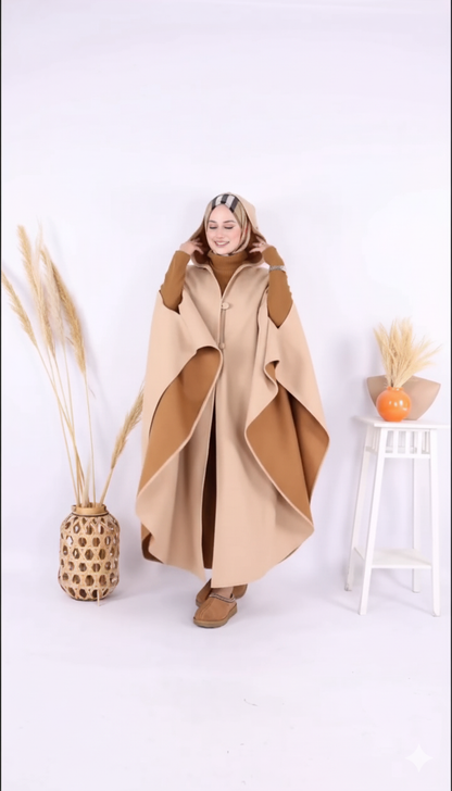 Person wearing a beige and brown cape with a white background