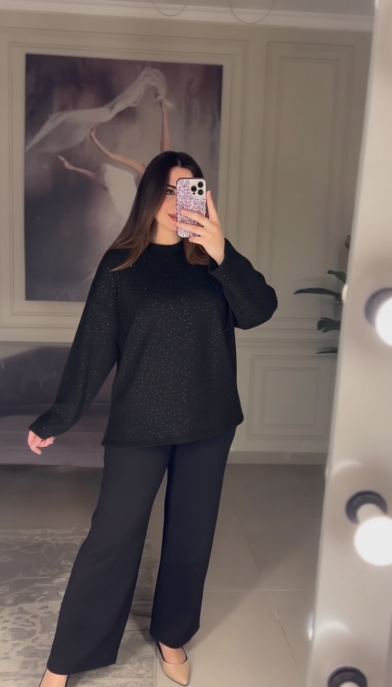 Person wearing a black outfit taking a mirror selfie in a room with a painting of a horse on the wall.