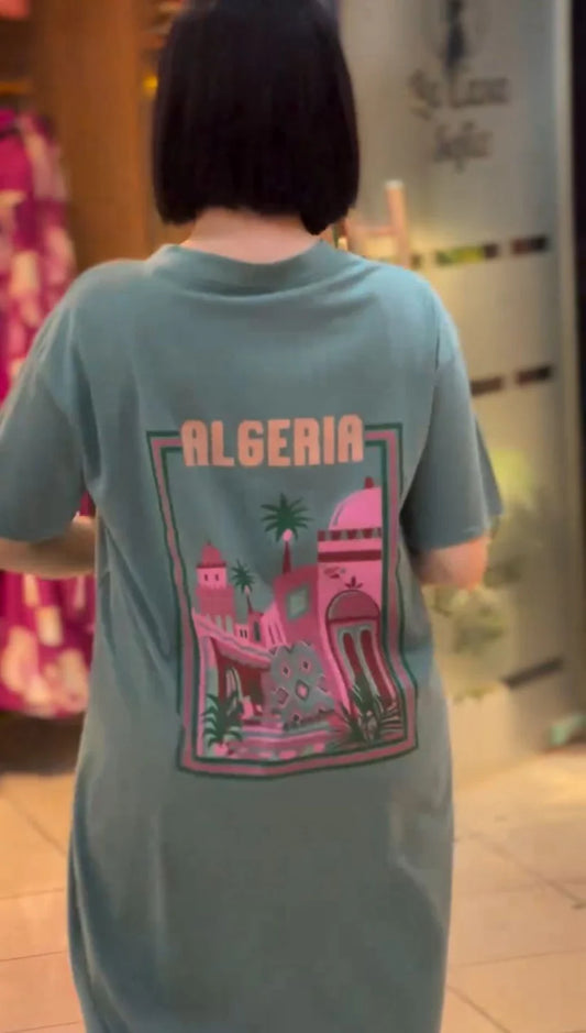 Short-sleeve t-shirt dress featuring a large "ALGERIA" graphic print with architectural and palm tree illustrations on the back 01