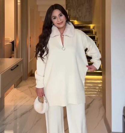 Woman in a white outfit standing in a modern interior setting