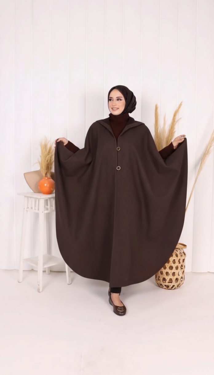 Woman wearing a brown abaya in a minimalistic setting