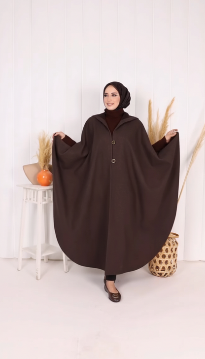 Woman wearing a brown abaya in a minimalistic setting