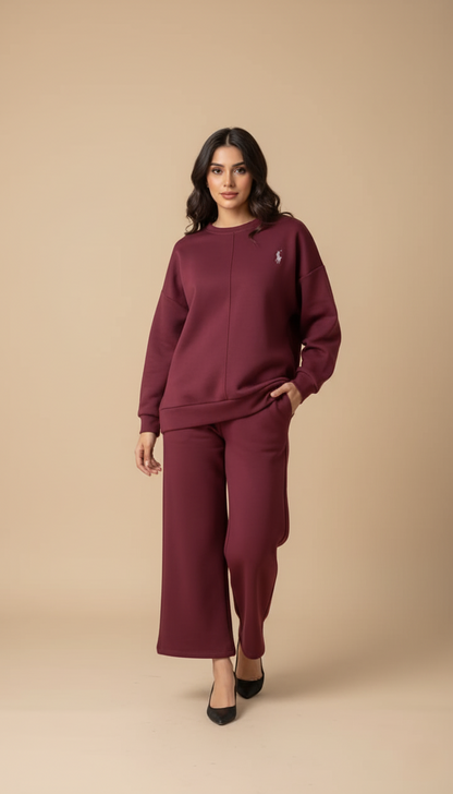 Woman wearing a burgundy sweatshirt and pants on a beige background