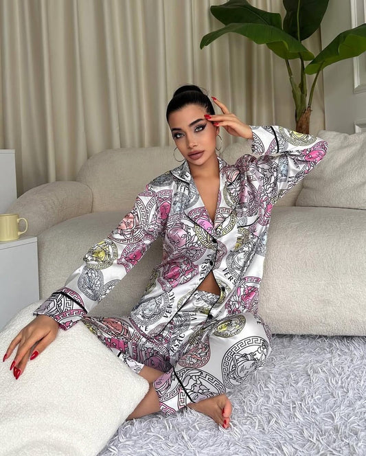 Woman in a patterned robe sitting on a couch in a living room.