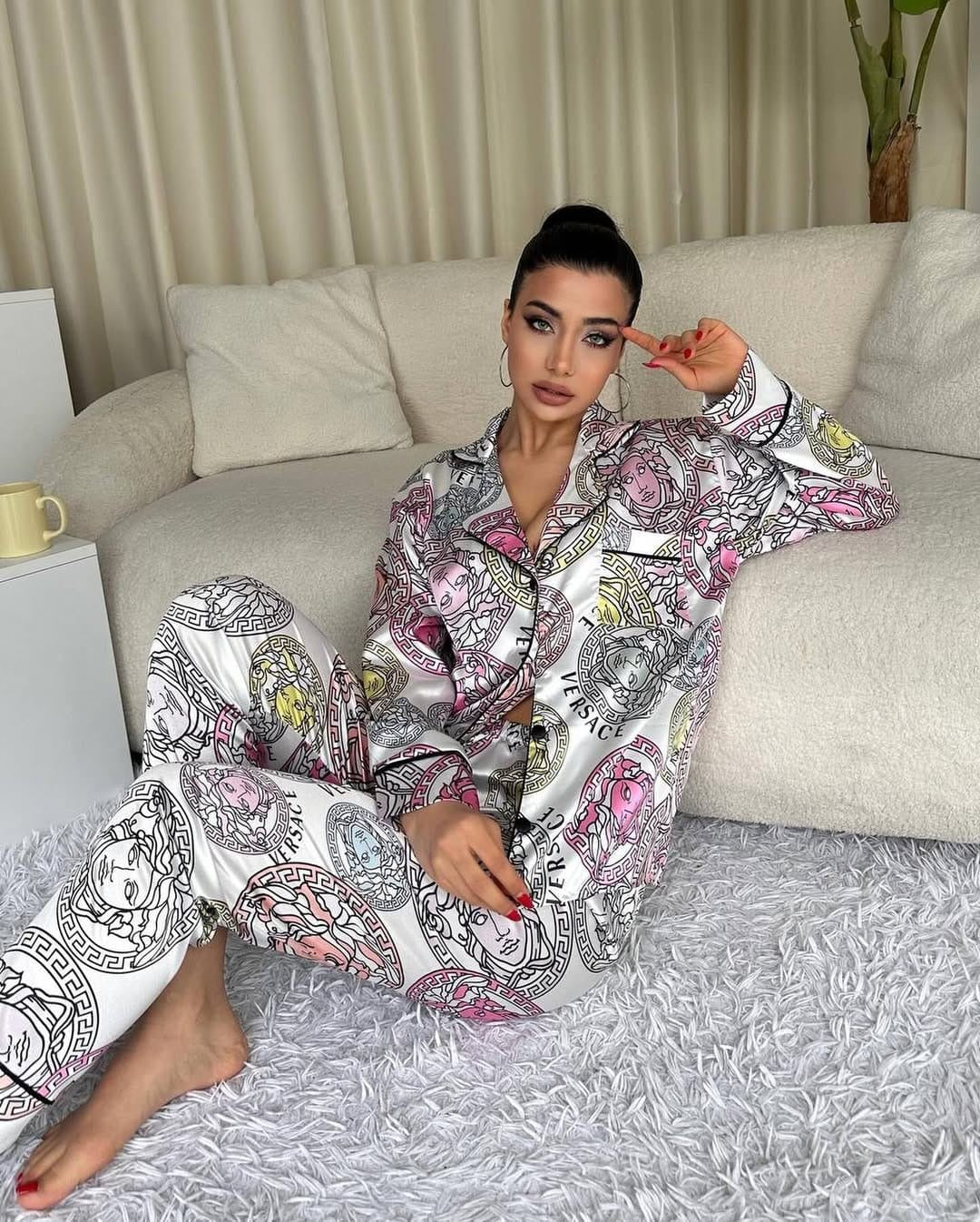 Woman wearing a patterned pajama set sitting on a couch.